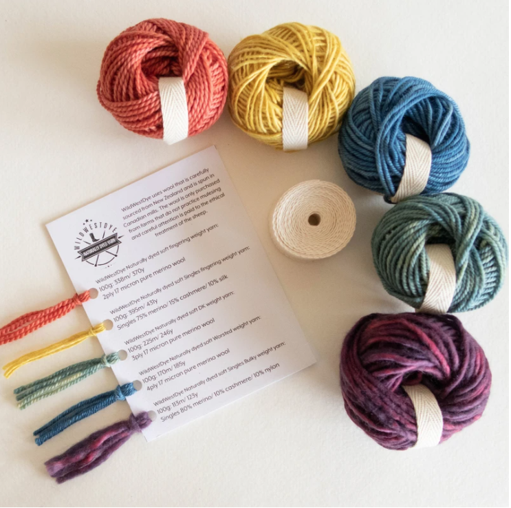 Spools of brightly colored yarn and yarn swatches.